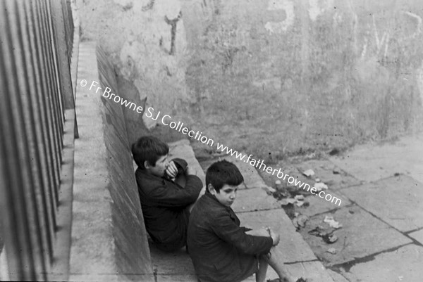 CHILDREN SITTING IN HANDBALL ALLEY